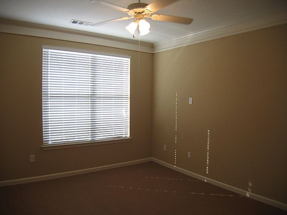 Spacious Master Bedroom with Ceiling Fan and Crown Molding