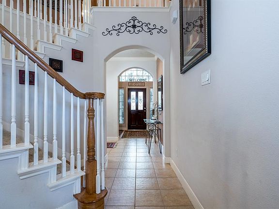 An arched window and leaded glass door with sidelights allows the natural light to flow into the entry and creates a warm sense of home!