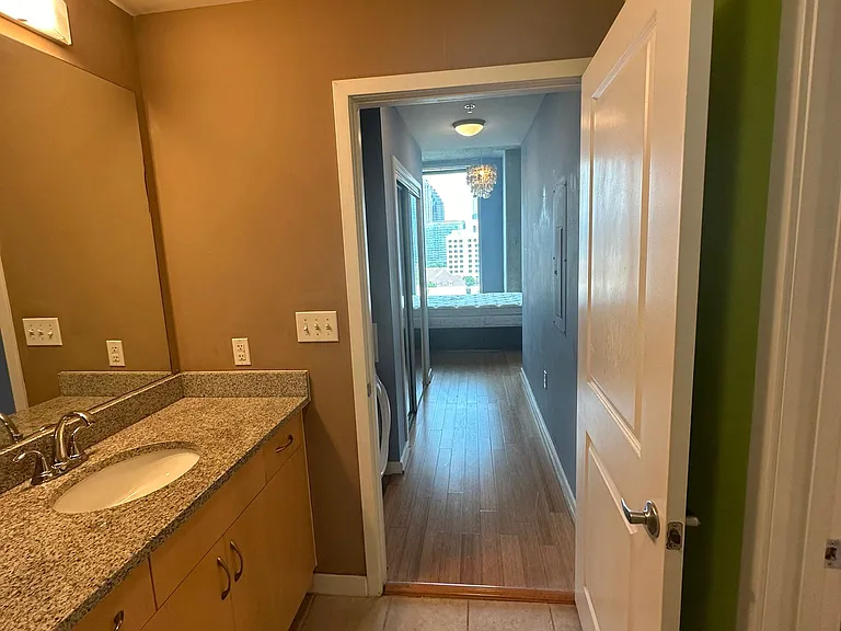 Bathroom. Outside of bathroom, to the left is the stacked washer/dryer.