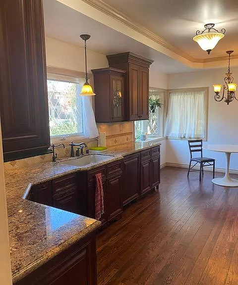 Elegant kitchen with granite counters looking out to the front yard.