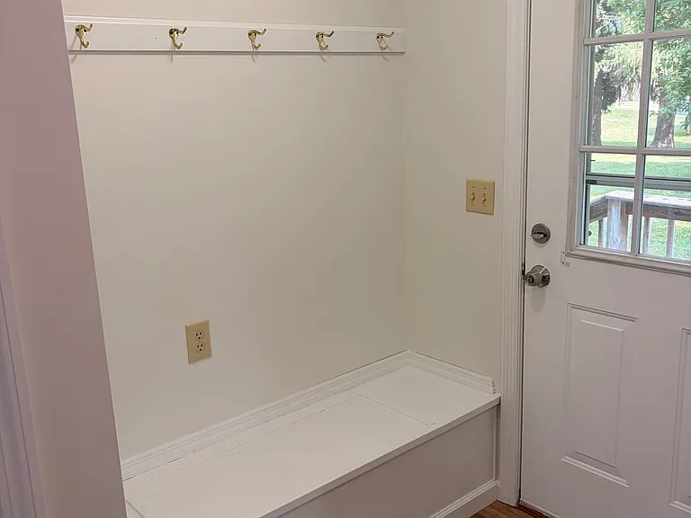 south entrance with coat hooks and bench
