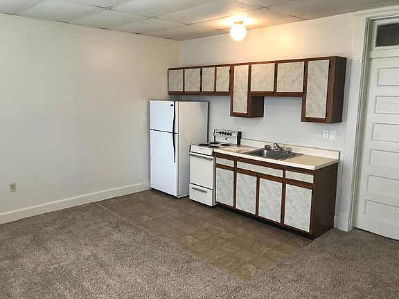 In living room looking at kitchen area and front door on right