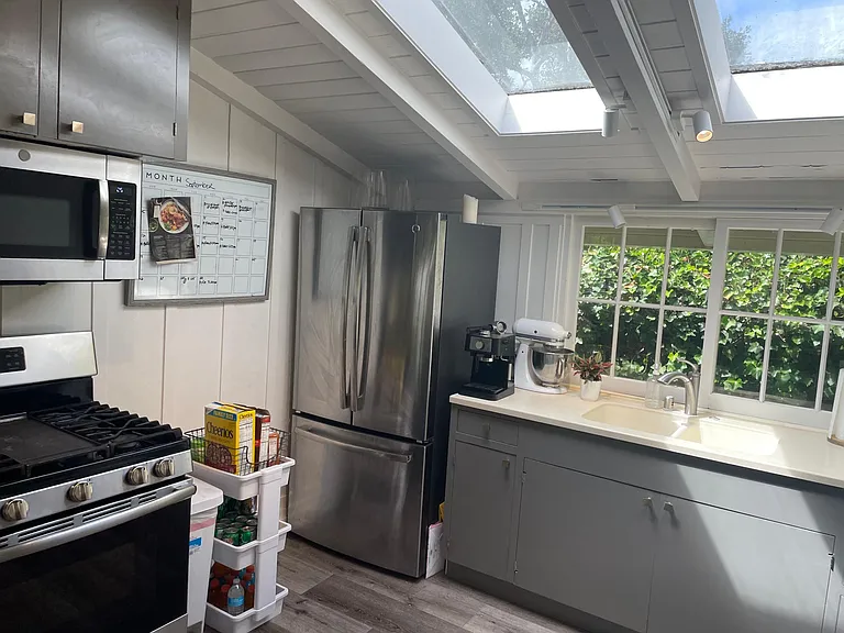 Kitchen with bright and airy ceilings with skylight and large window