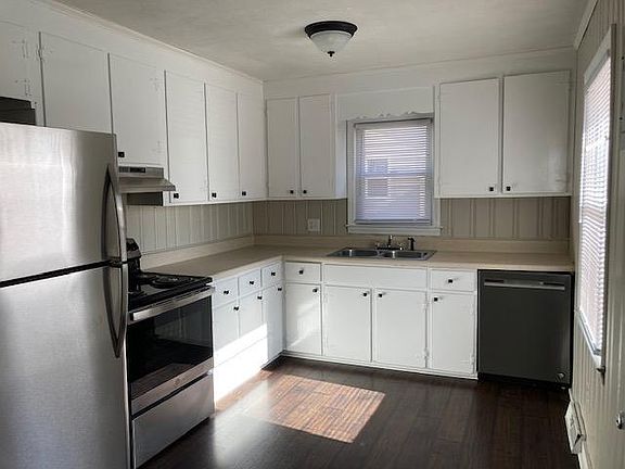 Kitchen with new stainless-steel fridge, dishwasher, range and range hood.