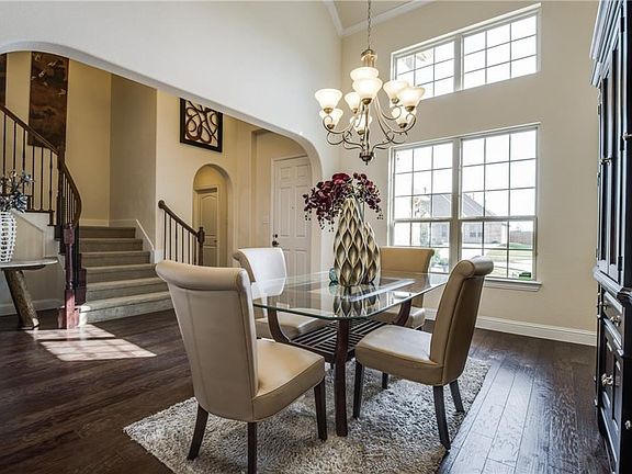 View of the formal dining room as looking back towards the entry. Notice the crown molding and elegant lighting!