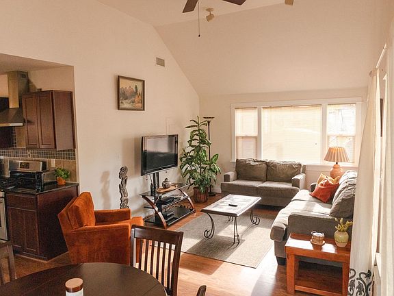 Large vaulted ceiling living room with ample seating and table space for dining.