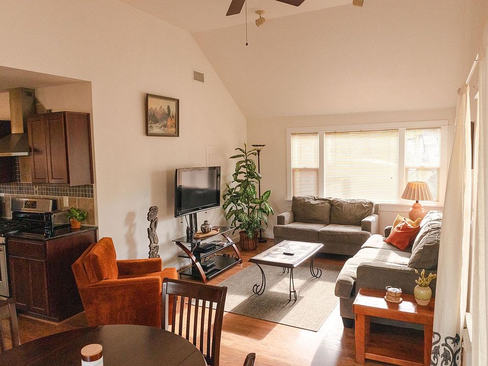 Large vaulted ceiling living room with ample seating and table space for dining.