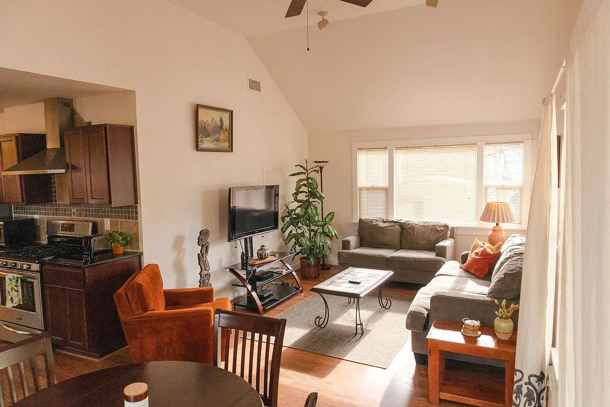 Large vaulted ceiling living room with ample seating and table space for dining. - 55 Howard Ave