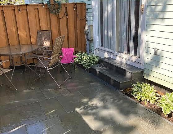 New raised slate patio off living room with privacy fence.
