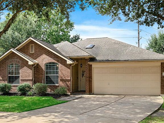 This is the front of the home with its mature trees and lush shrubbery.