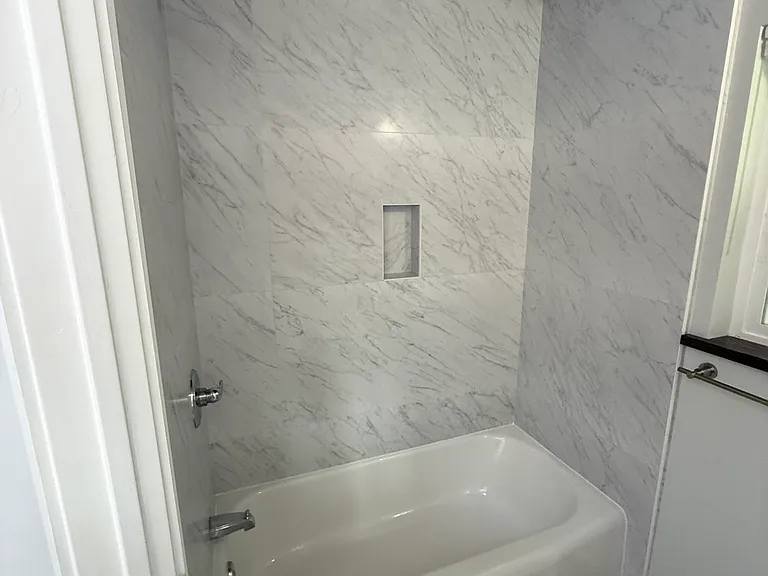Hallway Bathroom #1 has 2 sinks and a bathtub.