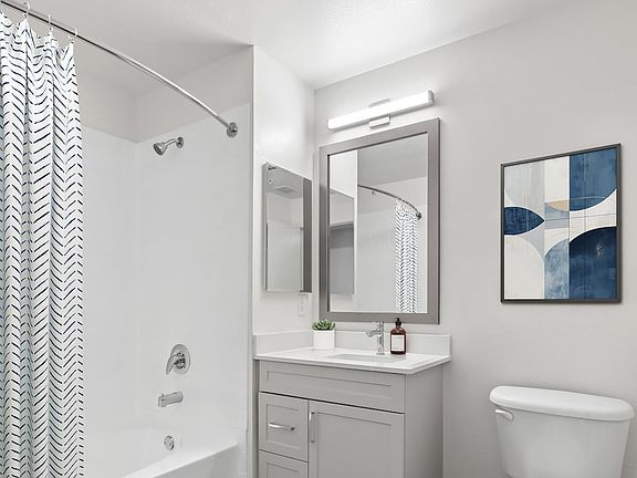 Renovated Package II bath grey cabinetry, white quartz countertops, and hard surface flooring
