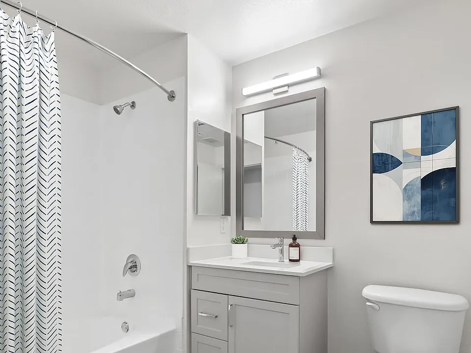 Renovated Package II bath grey cabinetry, white quartz countertops, and hard surface flooring