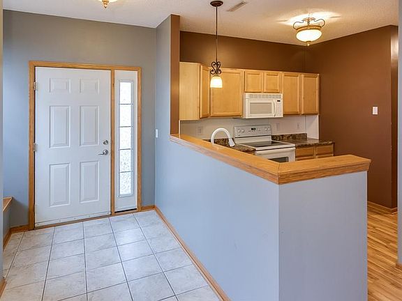 Open entryway has ceramic tile for easy clean up with coat closet and bench.