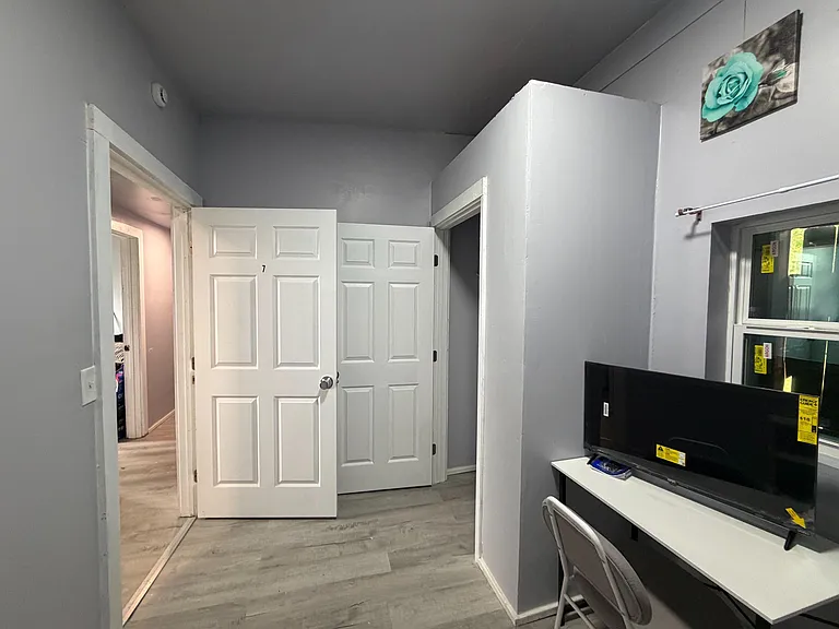 Flexible room setup with durable flooring, neutral walls, and nearby window spaceideal for a bedroom and small desk area.