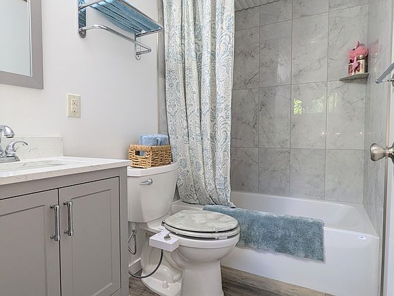 2nd full bathroom with tub, porcelain tile walls on lower level attached to the bonus room.