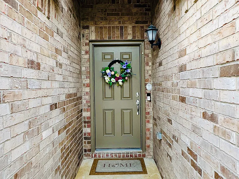 Beautiful front entryway with classic brick surroundings and a stylish front door, featuring a Ring video doorbell camera for enhanced security and convenience.