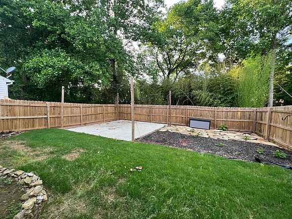 Large spacious newly renovated backyard including concrete space, string lights with extension cord, storage box, tiles, and grass area!