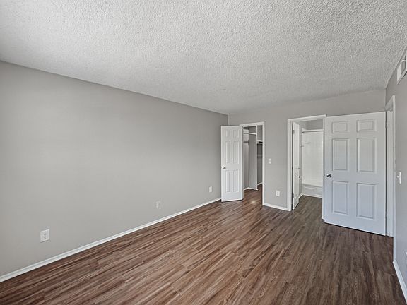 Spacious primary bedroom in the two-bedroom apartment with updated flooring