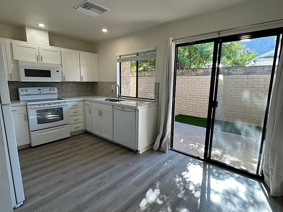 Kitchen with quartz countertops, microwave, stove and refrigerator
