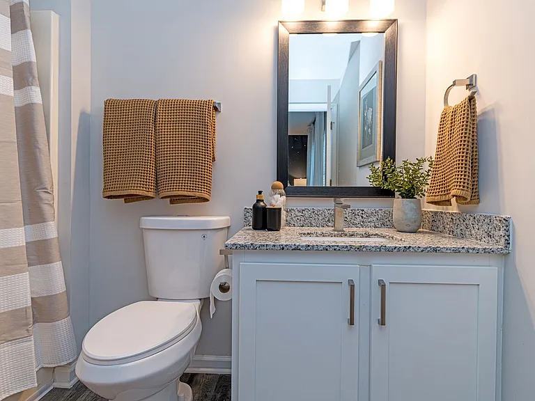 Bright bathroom with granite counters & modern cabinetry