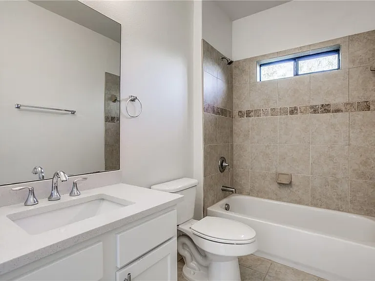 Second bath with updated cabinetry and tile surround tub/shower combo.