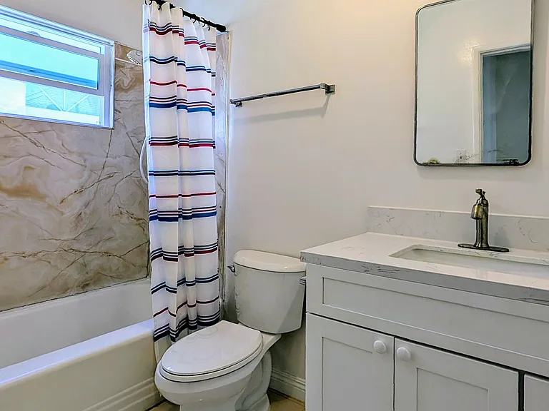Bathroom (newer tile floor, toilet, quartz counter top, sink, and vanity)