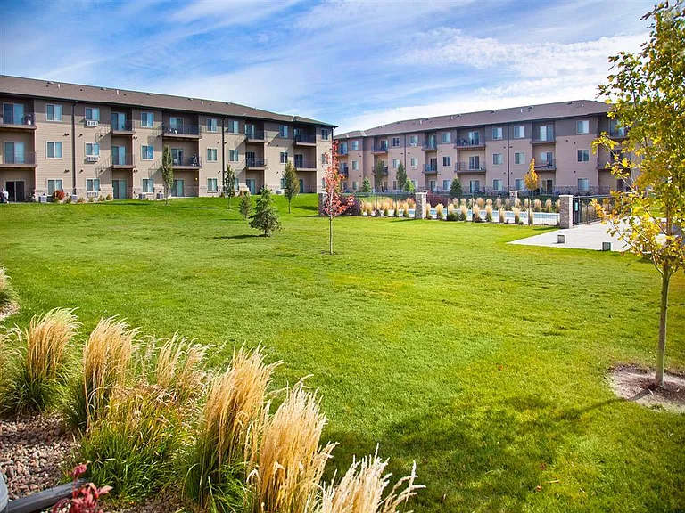 Landscape and community pool between the apartment buildings at The Sterling Kearney.