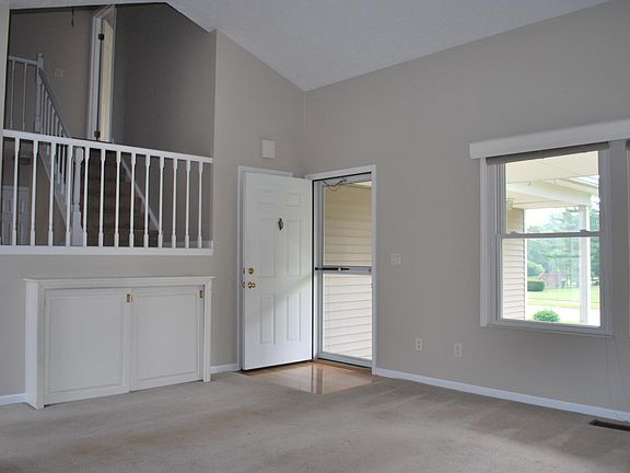 The staircase landing overlooks the cathedral ceilinged living room.