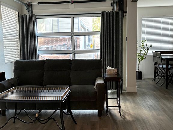 View of Great Room with view of garage door that opens to the patio. Dining area is to the right.