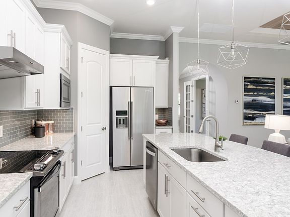 Thoughtfully designed kitchen with personalized upgrades, tile backsplash, stainless steel appliance