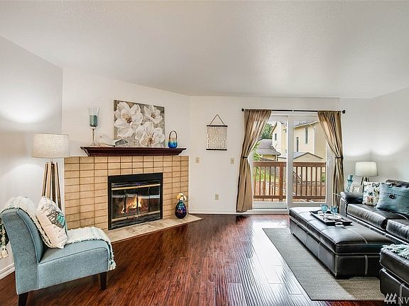 Bright living room space with wood burning fireplace.  Slider glass door leads to fully-fenced backyard. 