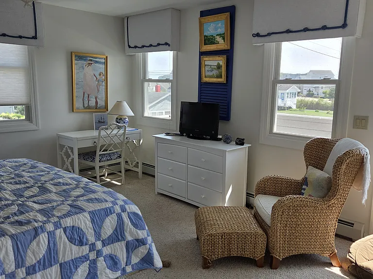 Main bedroom with desk . Windows looking over the water and exit to upper deck