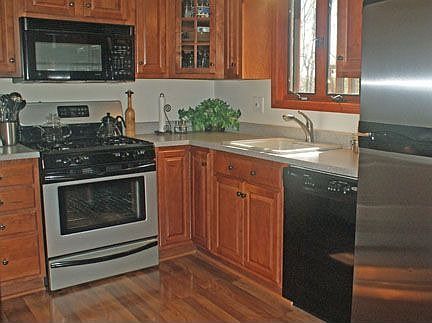 Custom Kitchen with new stove, dishwasher & Pergo floor.