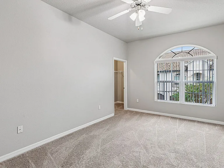 Bright and airy bedroom with plush carpet, large window showcasing scenic views, and a convenient walk-in closet.