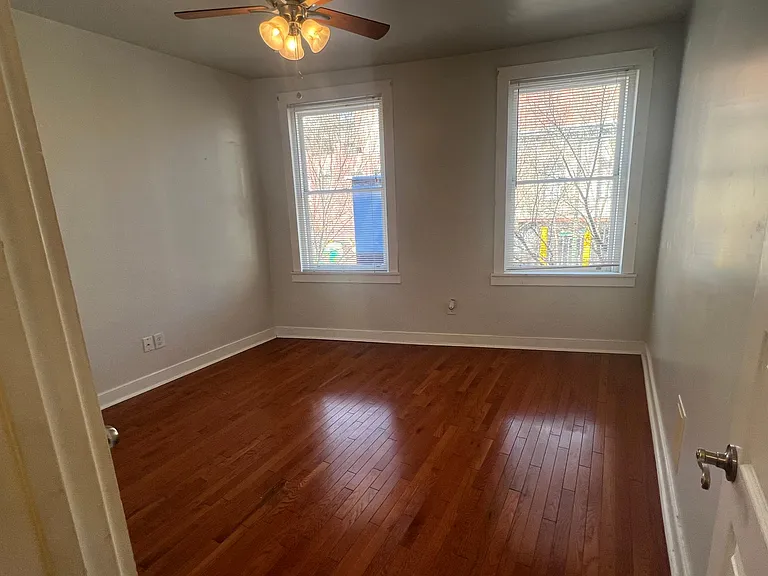 Excellent light, ceiling fan and hardwoods in Bedroom 1.