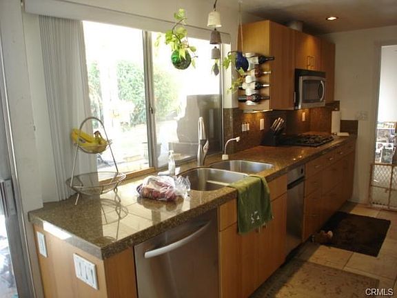 Granite counters, stainless steel sink, dishwasher, trash compac