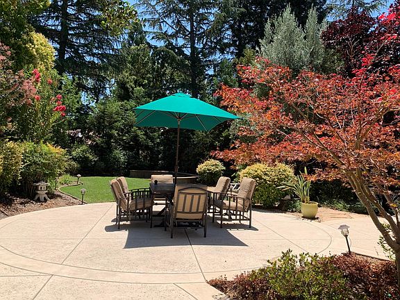 Backyard with mature treesincluding patio furniture