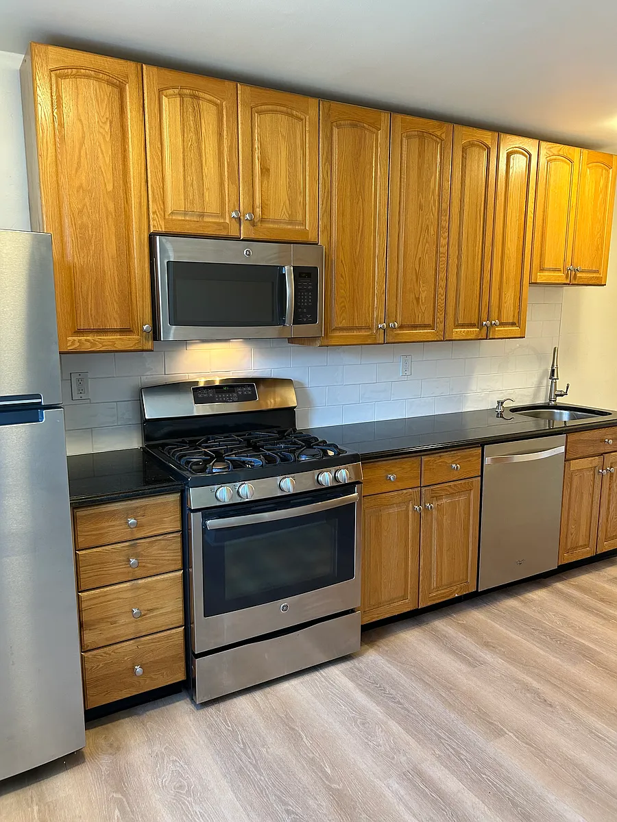 Kitchen with granite counters, stainless steel appliances: dishwasher, gas stove, refrigerator, and garbage disposal. - 3607 Weightman St