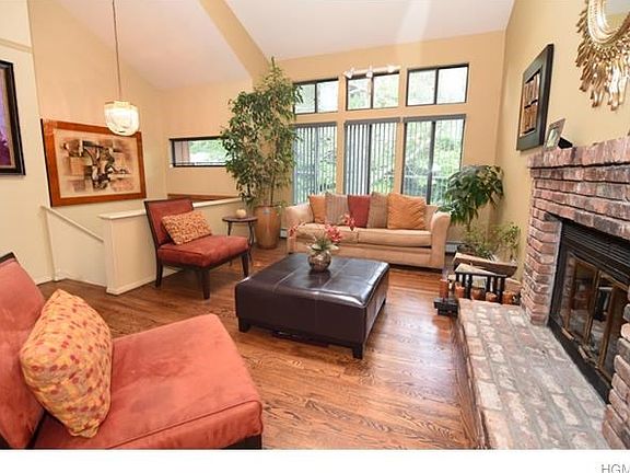 Living room with brick fireplace and hardwood floors.