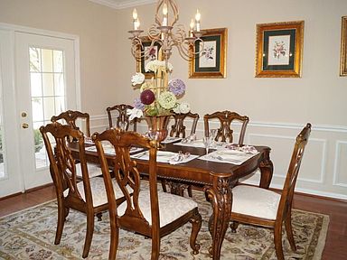 Formal dining room features French doors to front porch and gleaming wood floors...