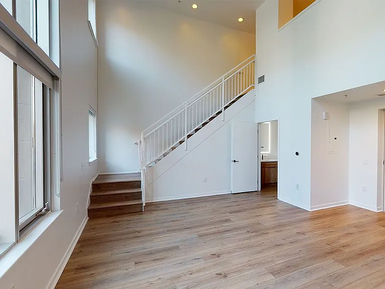Apartment dining and living room with wood-style flooring.
