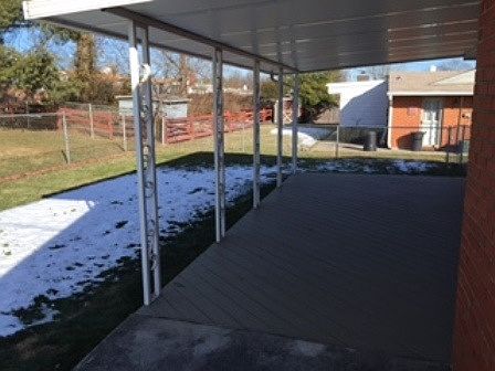 Large back patio in a fenced in yard.