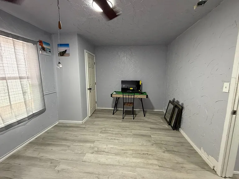 Versatile room with durable plank flooring, a window for natural light, and space for a desk or sitting area.
