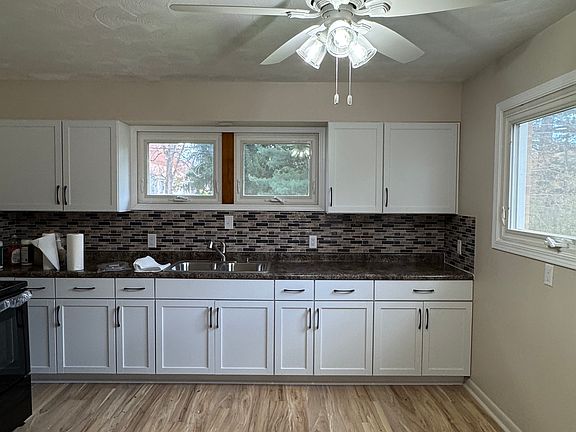 Large kitchen with all new cabinets, backsplash, stove, and refrigerator.