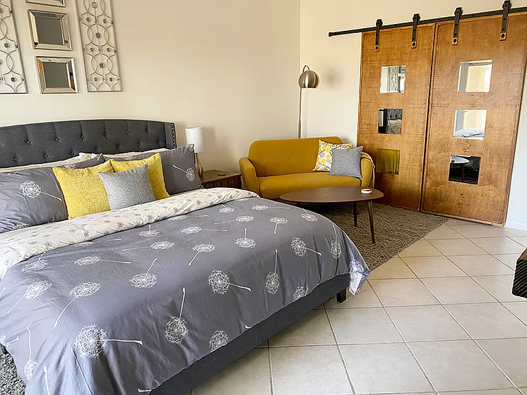 Yellow Bedroom: California King size bed, tall ceiling, walk-in closet, electric fireplace, back yard access, expansive desert and mountain views