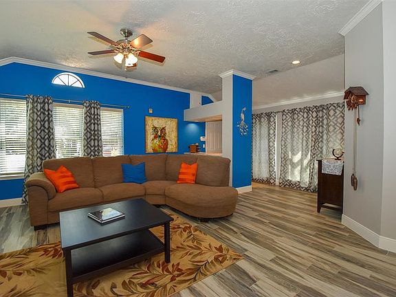 View of living room with architectural feature over a dry bar. Entry from garage with wall of windows open to a private atrium.