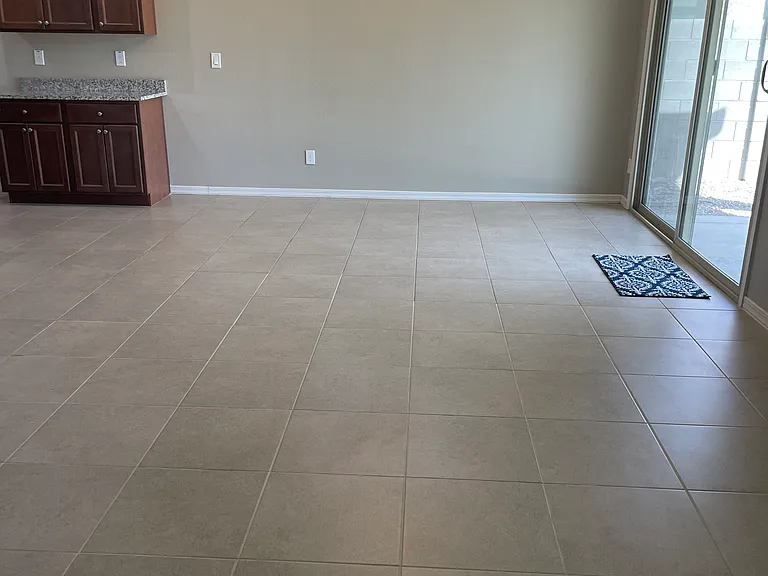Dining area with large sliding door to backyard. Partial view of living area also shown.