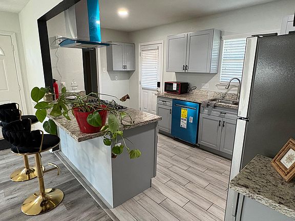 Updated kitchen with granite counters, breakfast bar seating, stainless appliances, and ample cabinet storage.