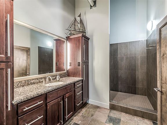 The large Bath is sure to impress! Cherry stained cabinets with door and drawer storage flanked by linen cupboard storage on each side. Massive walk-in shower with updated tile surround and floor. Sealed slate floors in Bath. There is a separate wate